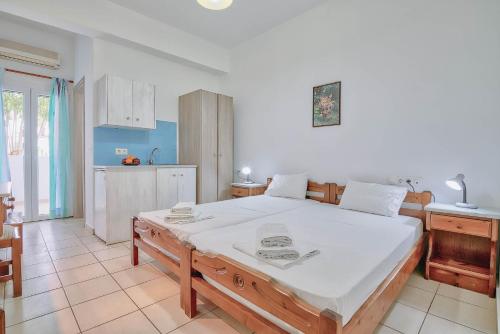 a bedroom with a large bed and a kitchen at Pavlos Place in Antiparos Town