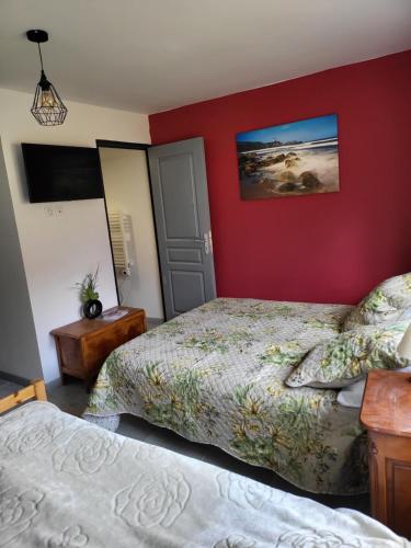 a bedroom with two beds and a red wall at Chambres hôtes de la Motte-Fanjas 