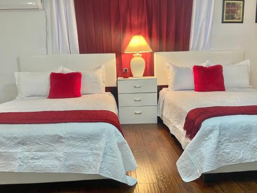 Duas camas com almofadas vermelhas num quarto em “Beautifull Cozy Studio…With Private Entrance” em Las Vegas