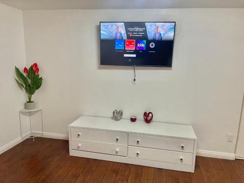 uma cómoda branca com uma televisão na parede em “Beautifull Cozy Studio…With Private Entrance” em Las Vegas