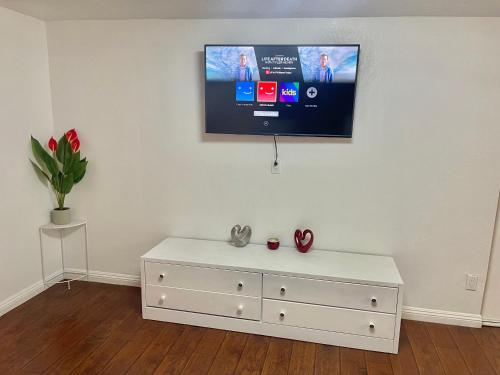 - une commode blanche avec une télévision murale dans l'établissement “Beautifull Cozy Studio…With Private Entrance”, à Las Vegas