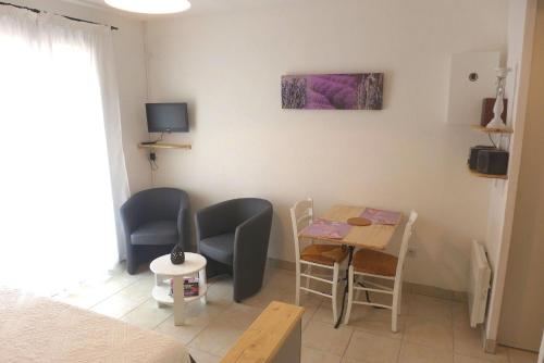 Cette petite chambre comprend une table, des chaises et un lit. dans l'établissement Studio meublé deux étoiles à DIGNE LES BAINS, à Digne-Les-Bains