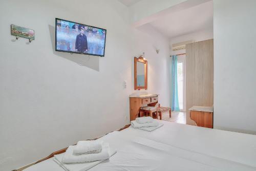 a bedroom with a bed with a tv on the wall at Pavlos Place in Antiparos Town