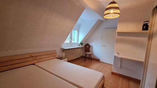 Cette petite chambre comprend un lit blanc et une fenêtre. dans l'établissement Ferienwohnung Ollywood Hill, 