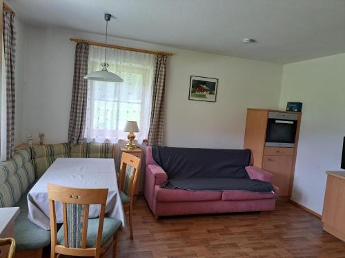ein Wohnzimmer mit einem Tisch und einem Sofa in der Unterkunft Althuberhof in Planca di Sopra