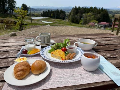 Una mesa con platos de comida para desayunar. en Hiraizumi Club -farm&resort- Vacation Stay, en Hiraizumi