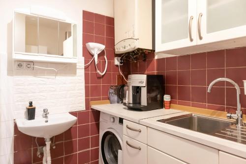 a small kitchen with a sink and a washing machine at Spacious & Pleasent 2BR Apt. near Milenium Tower in Vienna