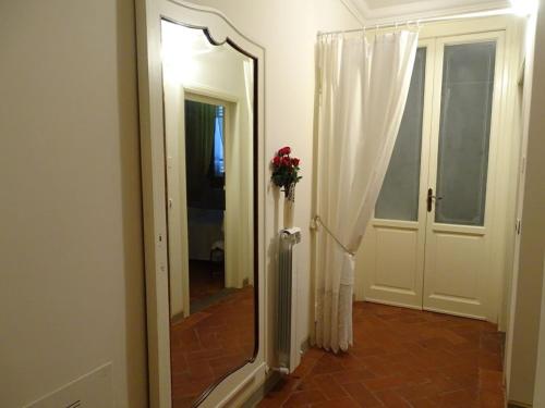 a hallway with a mirror and a door with a window at Il Nido della Formica in Colonnata