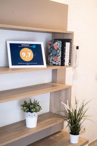 a laptop sitting on a shelf with plants at Stawowa Premium Apartment - 69 m2 with sauna and private garage in Kraków