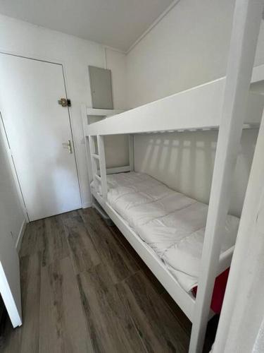 a white bunk bed in a room with a wooden floor at Les Tropéziennes in Cogolin