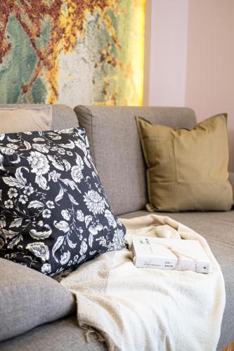 a book sitting on a couch with a pillow at Stawowa Premium Apartment - 69 m2 with sauna and private garage in Kraków