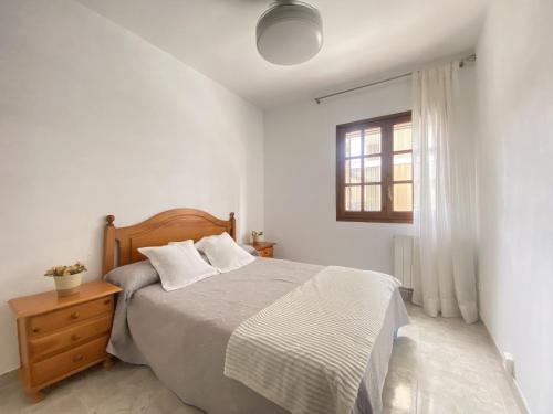 um quarto branco com uma cama e uma janela em R146 - Casa Residencial Estany em Calafell