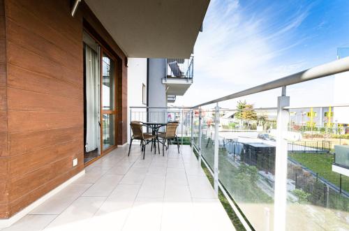 einen Balkon mit einem Tisch und Stühlen darauf in der Unterkunft Stawowa Premium Apartment - 69 m2 with sauna and private garage in Krakau