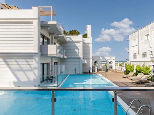 a swimming pool in front of a house at Diverso Platamon, Luxury Hotel & Suites in Platamonas