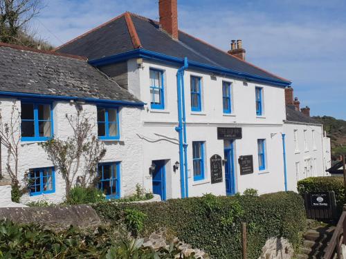 a white house with blue shutters on it at The Ship Inn in Truro