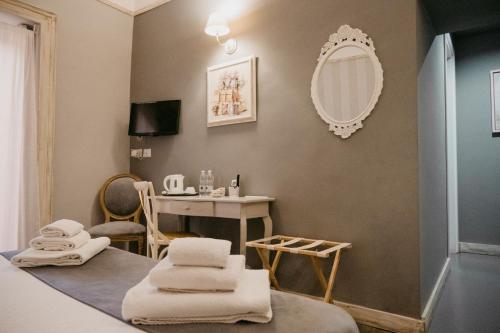 Pokój z lustrem i stołem z ręcznikami w obiekcie La Casa di Alma Luxury rooms w Katanii