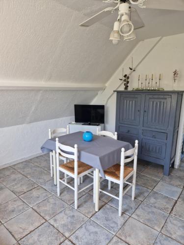 een eetkamer met een blauwe tafel en stoelen bij Gite du bois des sapins in Groffliers