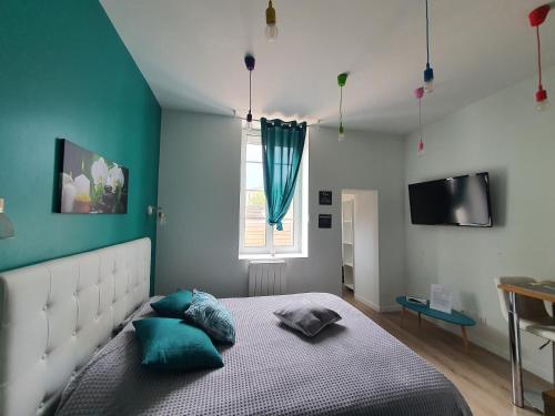 a bedroom with blue walls and a bed with blue pillows at "Le Petit Paradis" au Centre Ville d'Oyonnax in Oyonnax