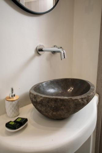 a bathroom with a stone sink and a mirror at Villa Jardin De Stelida in Stelida