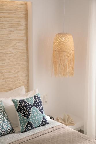 a bedroom with a bed with pillows and a lamp at Villa Jardin De Stelida in Stelida
