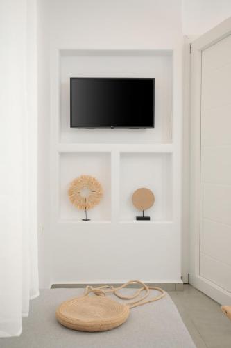 a living room with a tv on a white wall at Villa Jardin De Stelida in Stelida