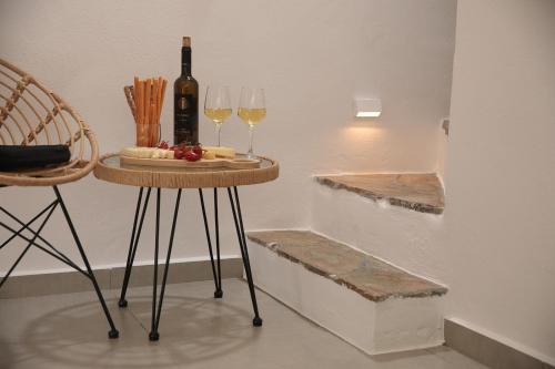 a table with two glasses and a bottle of wine at Villa Jardin De Stelida in Stelida