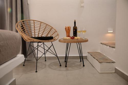 a table with a bottle of wine and a chair at Villa Jardin De Stelida in Stelida