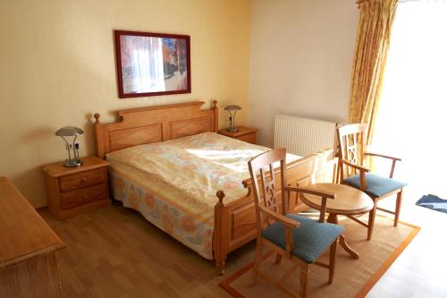 Schlafzimmer mit einem Bett mit 2 Stühlen und einem Tisch in der Unterkunft Haus Bergblick in Frauenwald