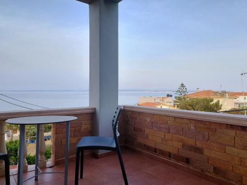 balkon ze stołem i krzesłami oraz widokiem na ocean w obiekcie Chios Shallow Sea w mieście Karfas