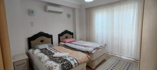 a small bedroom with two beds and a window at çileks apart otel in Fethiye