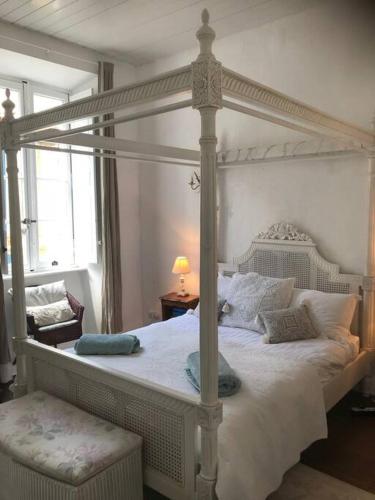 a bedroom with a large white bed with a canopy at Riverside 4 bed house full of character and charm in Quillan