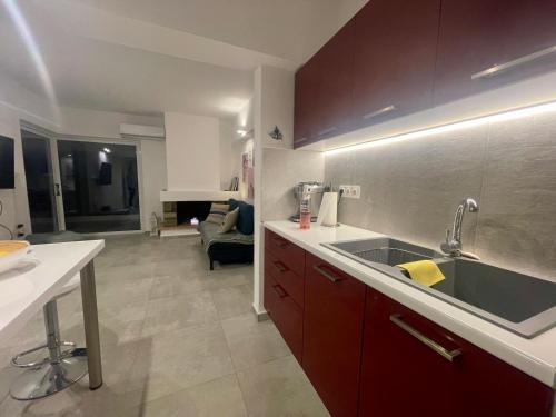 a kitchen with a sink and a living room at Sparkling dream in Saronida