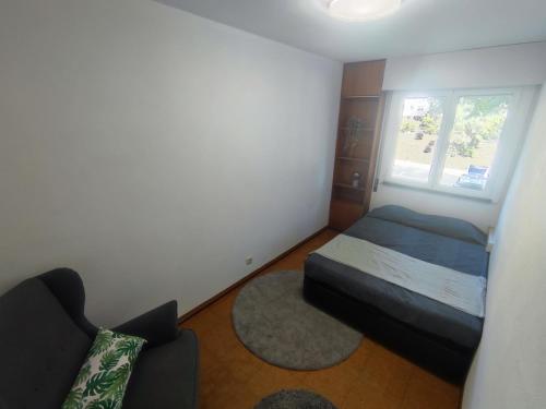 a small bedroom with a bed and a window at Aconchegante T3 em Telheiras in Lisbon
