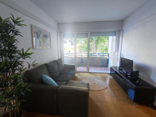 a living room with a couch and a television at Aconchegante T3 em Telheiras in Lisbon