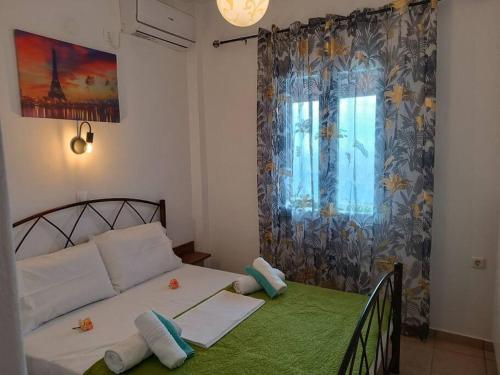 a small bedroom with a bed and a window at Aegean Star in Apróvaton