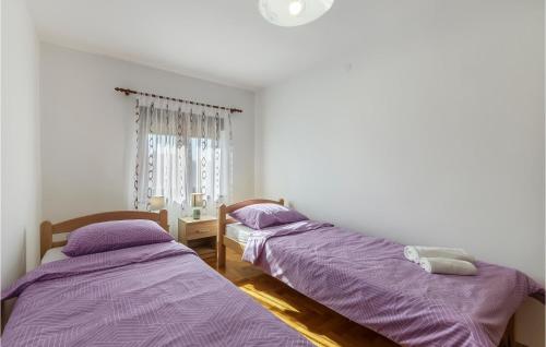 2 Betten in einem Zimmer mit lila Bettwäsche in der Unterkunft 3 Bedroom Gorgeous Apartment In Pula in Pula