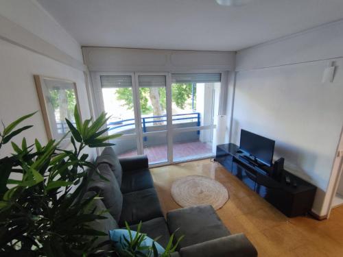 a living room with a couch and a television at Aconchegante T3 em Telheiras in Lisbon