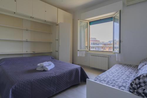 リド・ディ・オスティアにあるAppartamento Federicaのベッドルーム1室(ベッド2台、窓付)