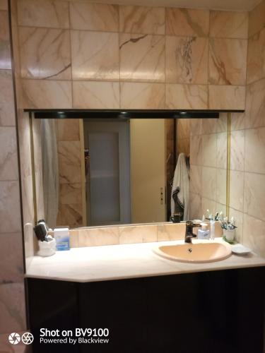 a bathroom with a sink and a large mirror at chambre double chez l'habitant in Strasbourg