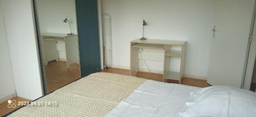 sypialnia z białym łóżkiem i lustrem w obiekcie chambre double chez l'habitant w Strasburgu