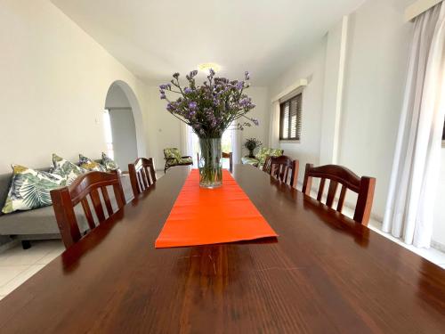 a vase of flowers on a table in a living room at Nysa7 in Paphos City