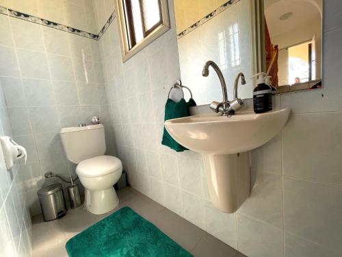 a bathroom with a sink and a toilet and a mirror at Nysa7 in Paphos City