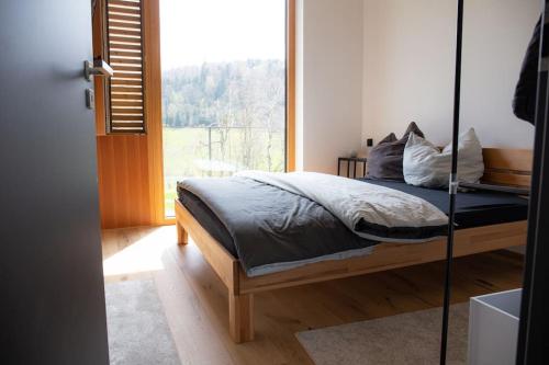 ein Schlafzimmer mit einem Bett und einem großen Fenster in der Unterkunft Tolle Bergvilla im Osterzgebirge in Kurort Altenberg