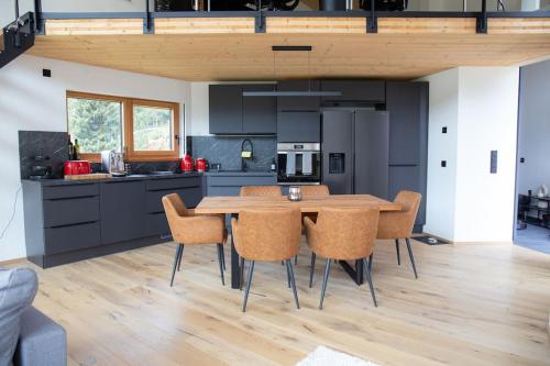 cocina con mesa de madera y sillas en Tolle Bergvilla im Osterzgebirge, en Kurort Altenberg