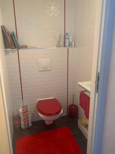 La salle de bains est pourvue de toilettes rouges et d'un tapis rouge. dans l'établissement Magnifique Villa privée avec Piscine proche Plage, à Marseille