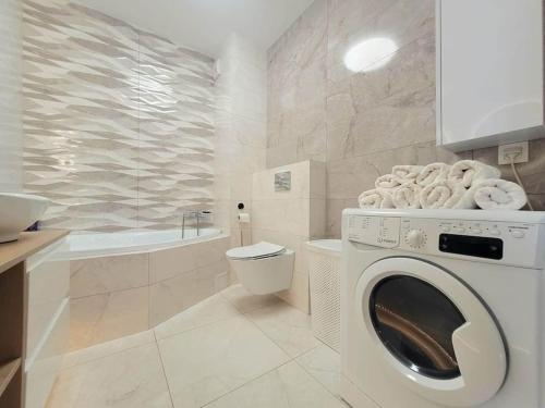 y baño blanco con lavadora. en Apartment Sophie 3 rooms, 2 bathrooms, 8 persons, en Cracovia