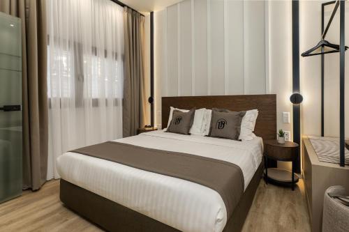 a bedroom with a large bed in a room with a window at Diverso Platamon, Luxury Hotel & Suites in Platamonas