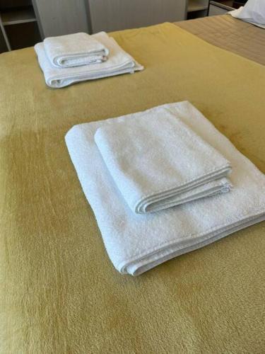 dos toallas blancas sentadas encima de una cama en Estepa Apart 1B calidad y confort en Comodoro Rivadavia