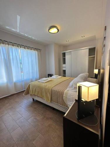 1 dormitorio con 1 cama y 1 mesa con lámpara en Estepa Apart 1B calidad y confort en Comodoro Rivadavia