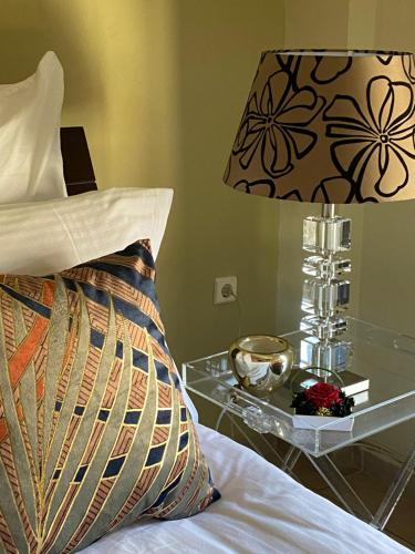 a bed with a lamp and a glass nightstand with a bed sidx sidx sidx at Villa Aurelia Old Town in Kavala